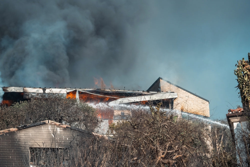 A house on fire with smoke coming out of the roof